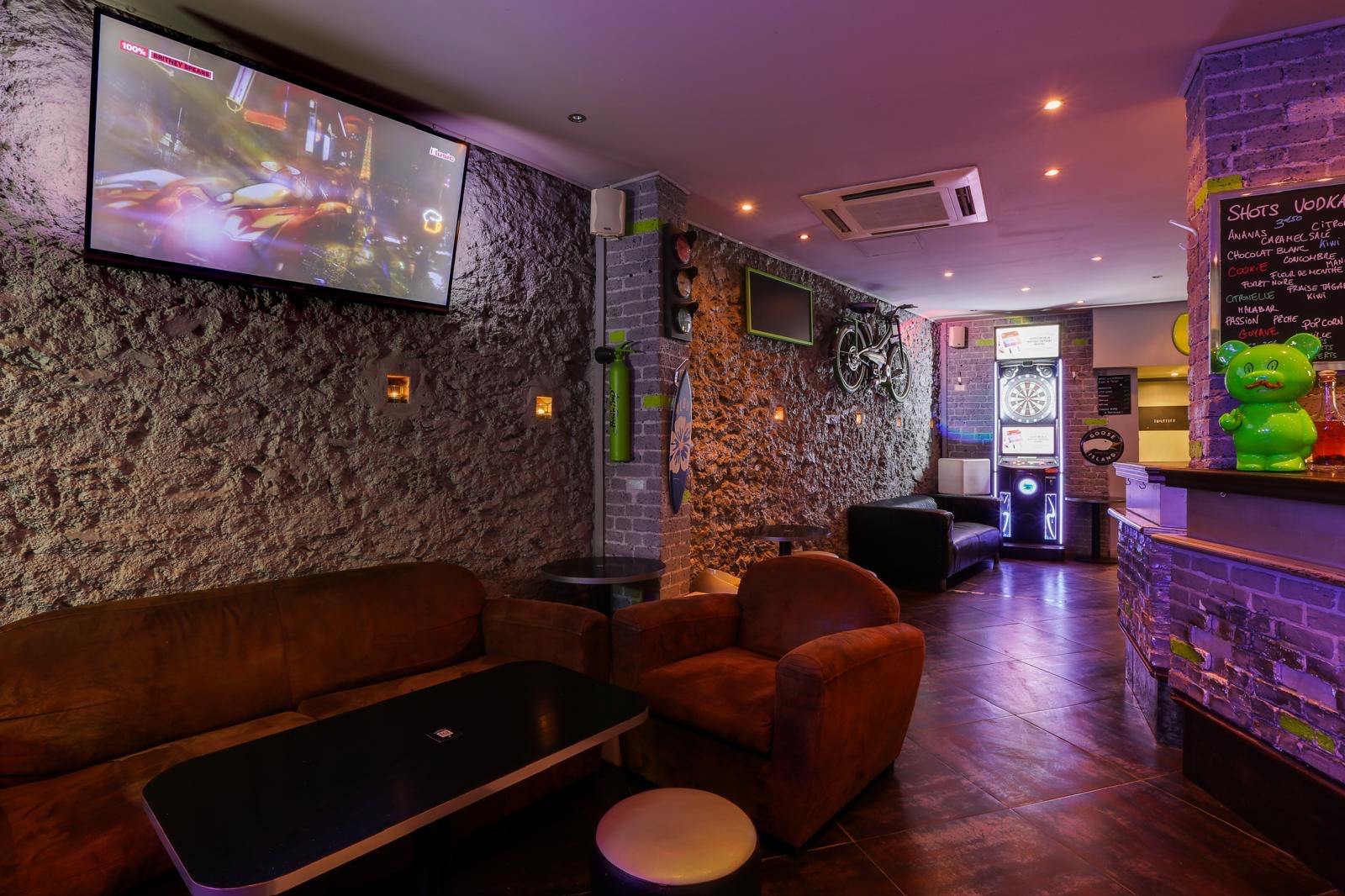 Canapés rouges, TV et ambiance chaleureuse