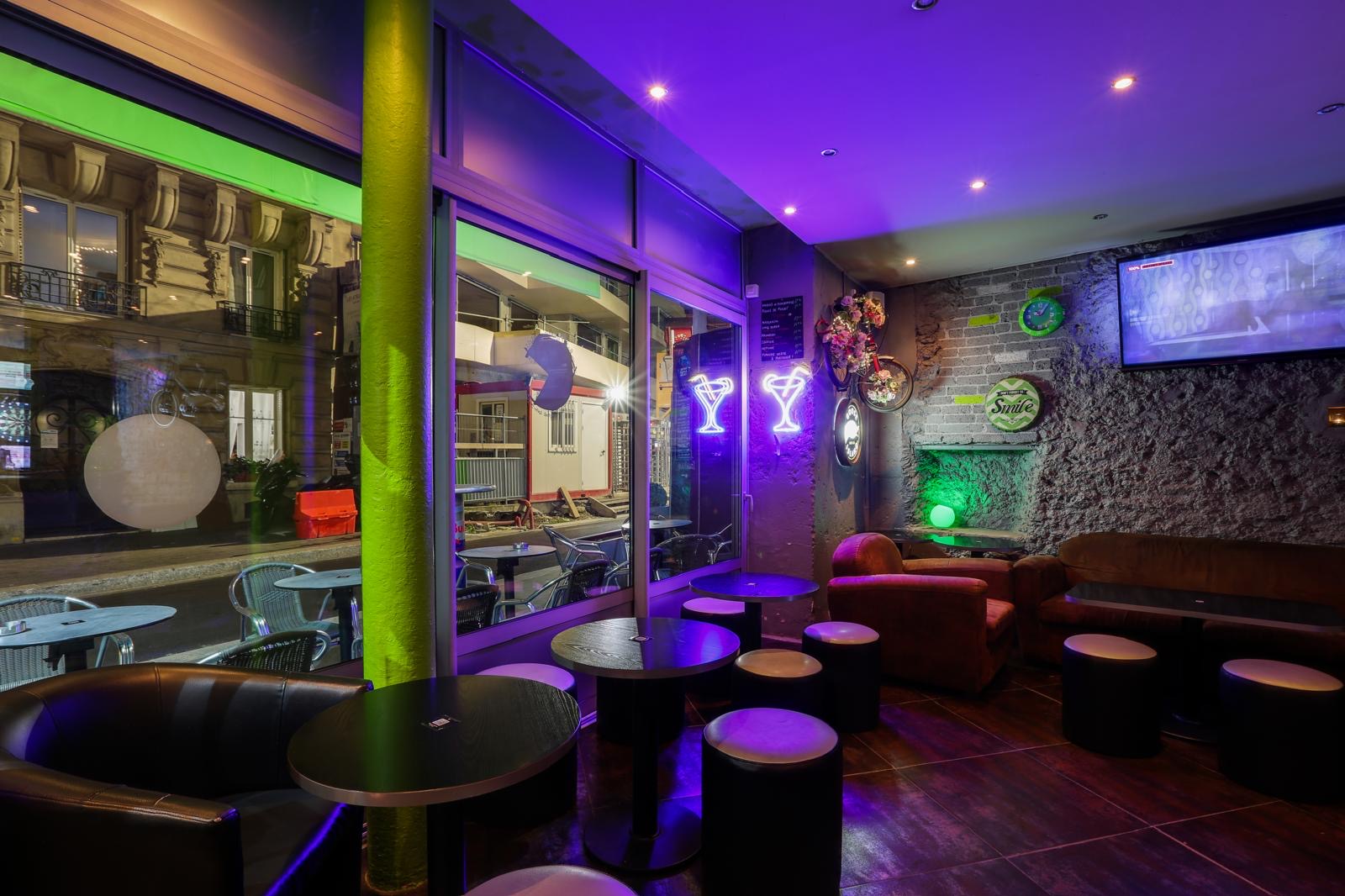 Entrée du bar la nuit, néons cocktails et terrasse