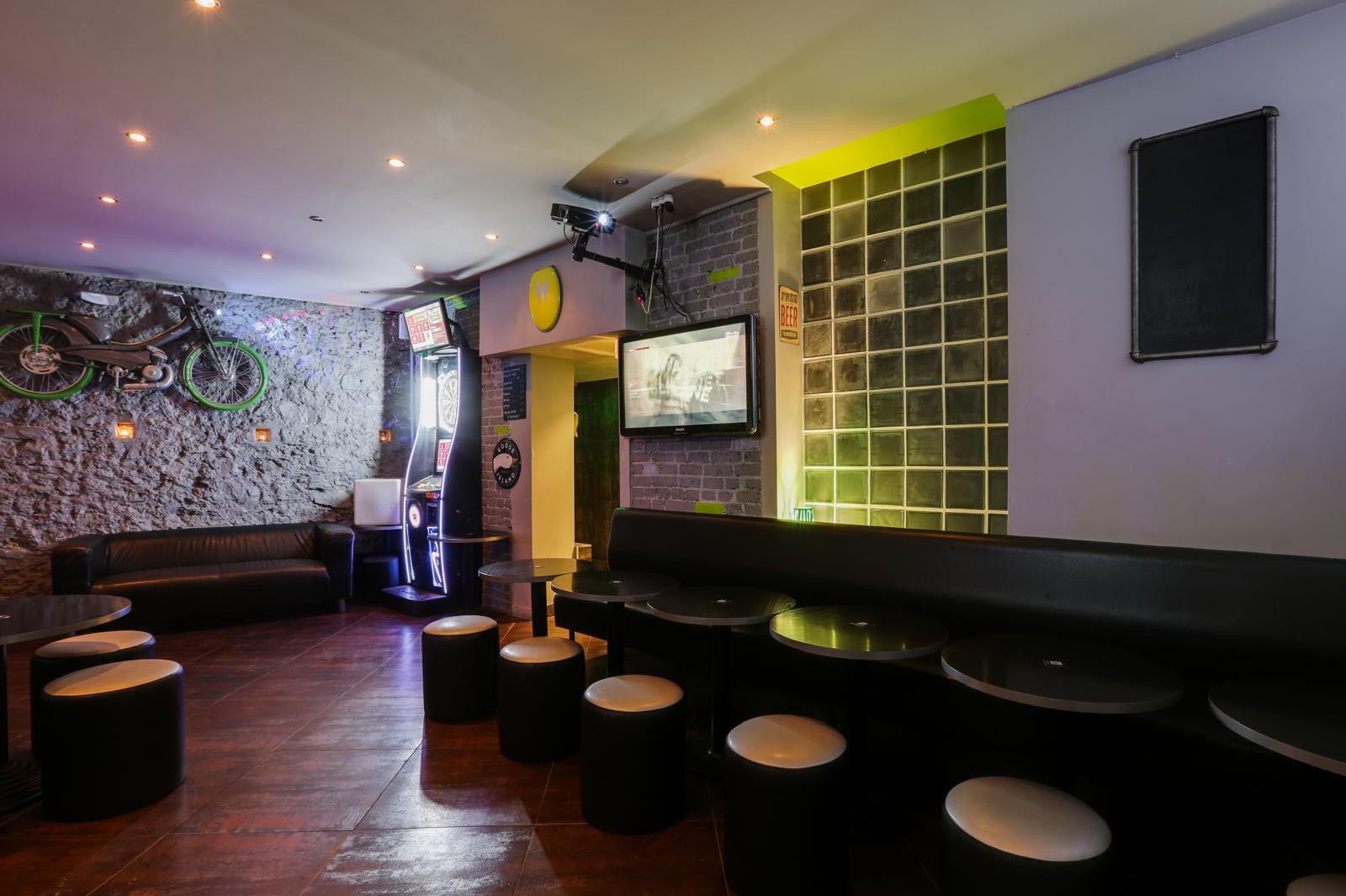Fond de salle la nuit, banquettes noires et blocs de verre verts